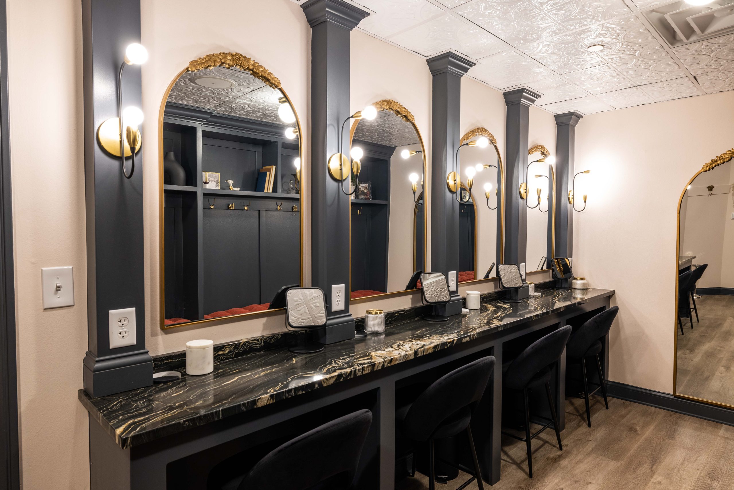 A beautiful commercial counter for makeup and hairstyling is complete with light fixtures that add style and provide perfect lighting for makeup application.